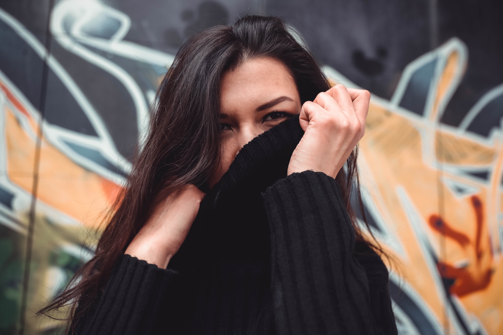 woman covering her face on black sweater