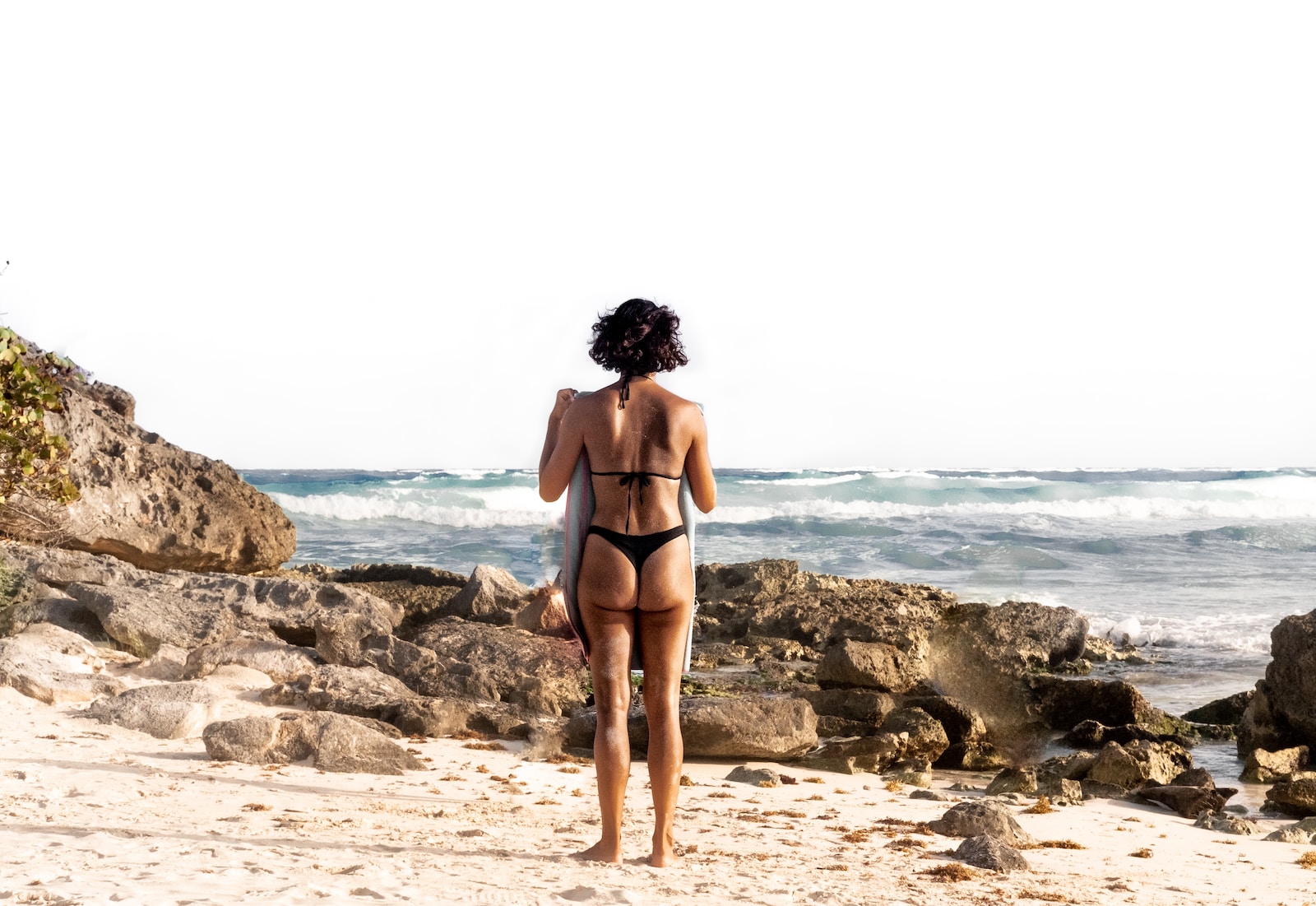 woman in black bikini standing on beach during daytime